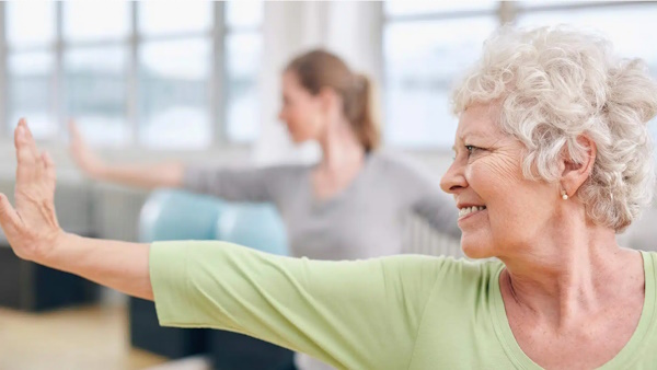 An older woman stretching her arm out in front of her