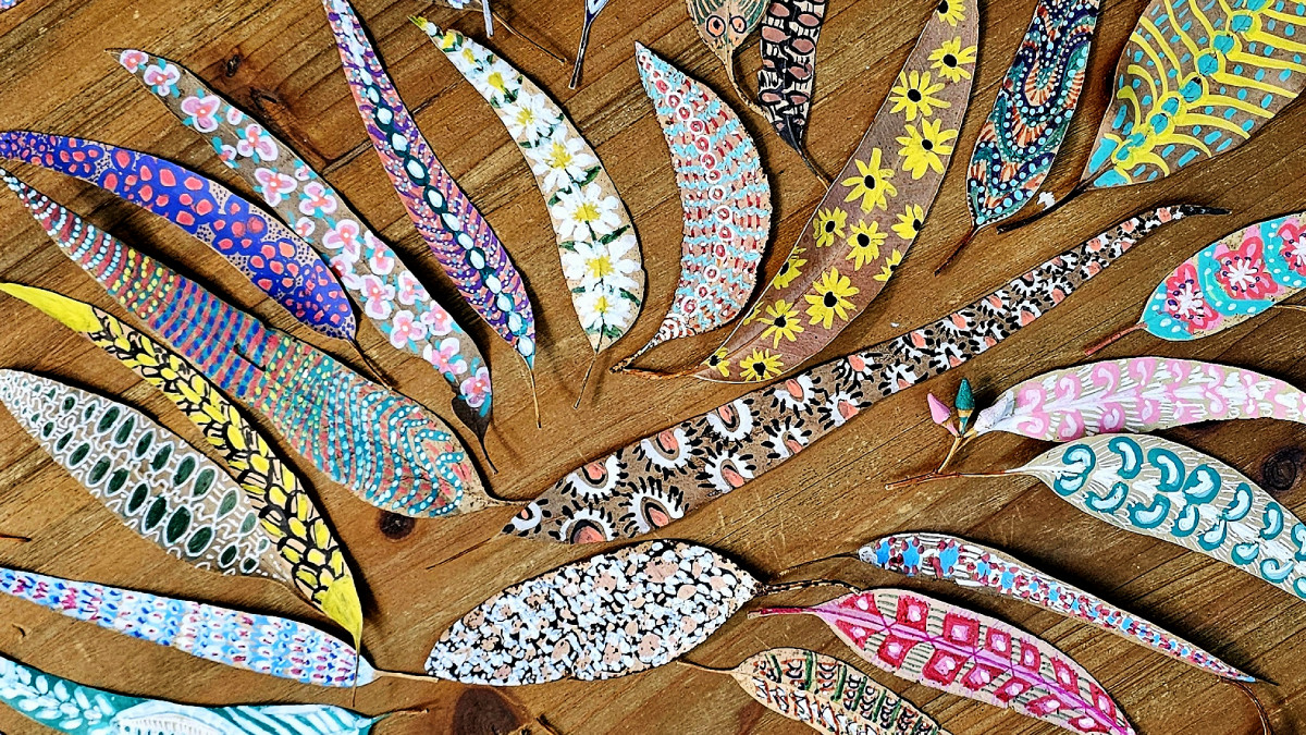 A collection of beautifully painted leaves on a wooden table