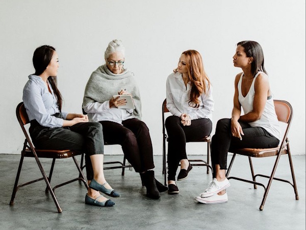 A group of women sitting on chairs in a semi circle